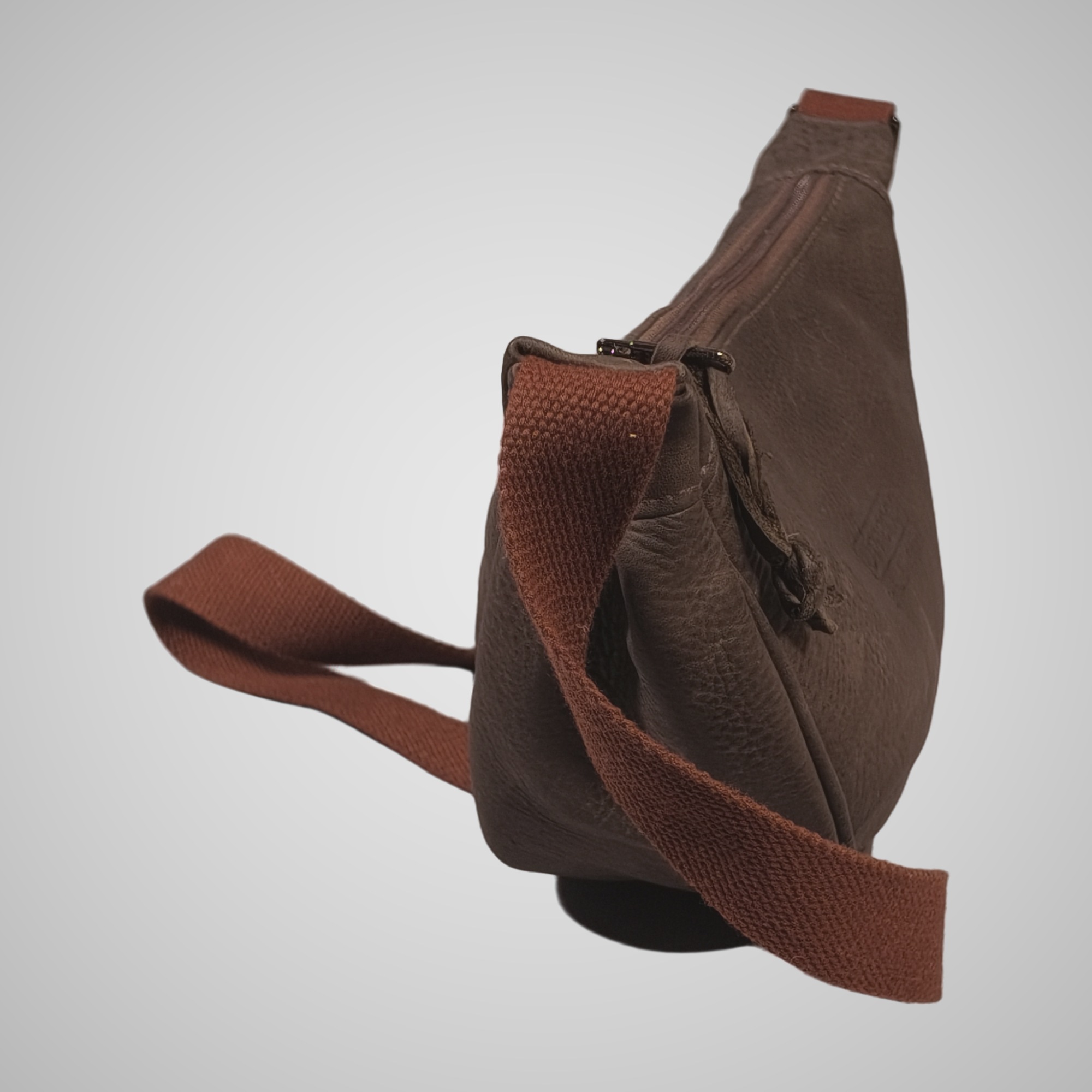 End view of Lumengin Half Moon brown distressed leather cross-body bag showing pleated side panel and strap