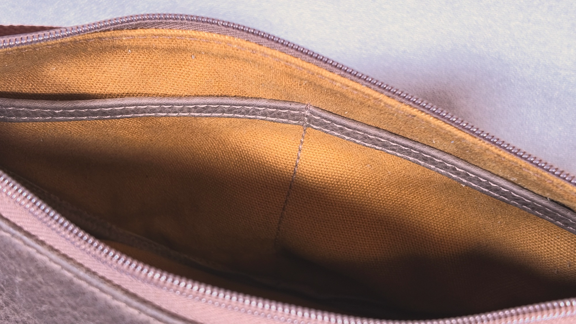 Inside Lumengin Half Moon cross-body bag: tan canvas lining with open slip pocket under the zipped top