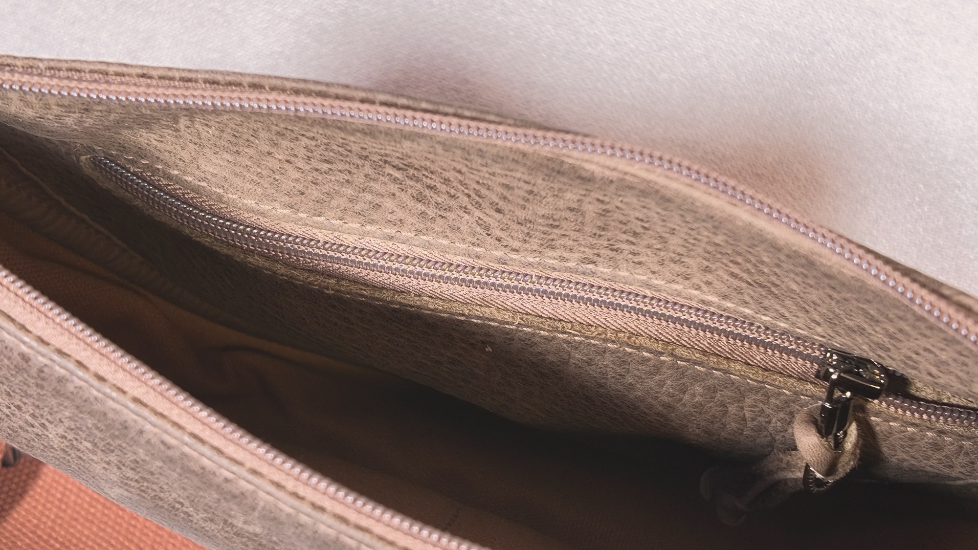 Inside Lumengin Half Moon cross-body bag: internal zipped pocket on the brown distressed leather inner panel