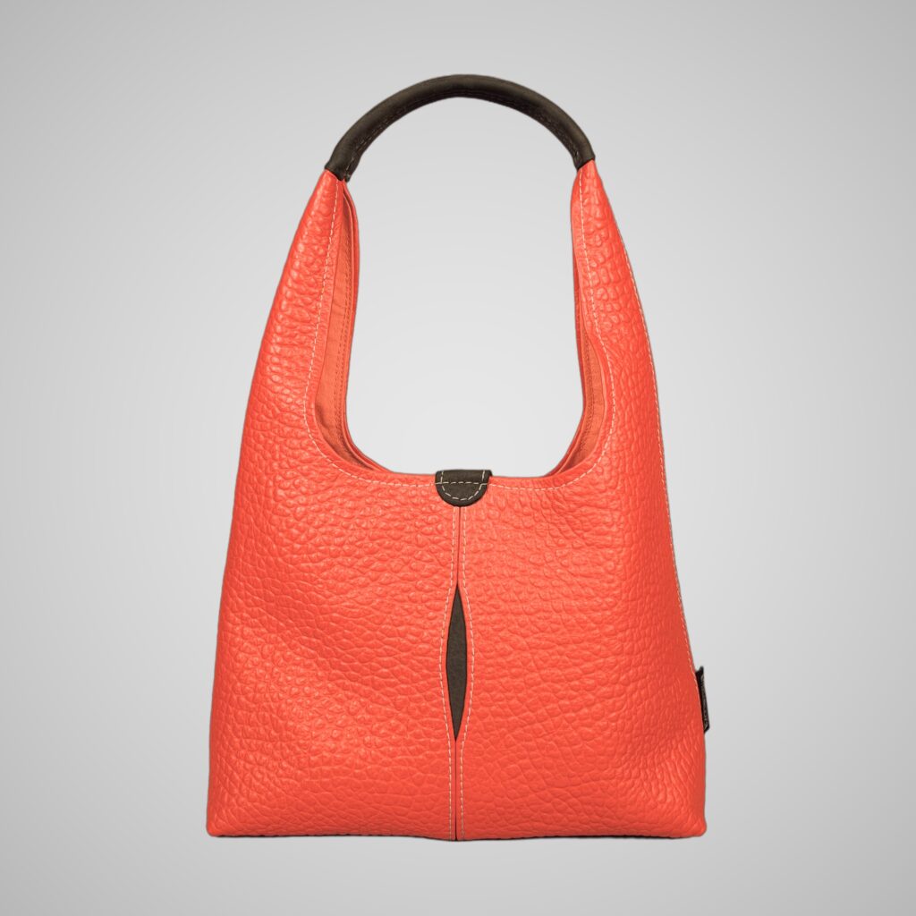 Front view of Lumengin Bubble Orange medium hobo bag in bright orange pebbled leather with dark grey handle and dark grey tab, on soft grey