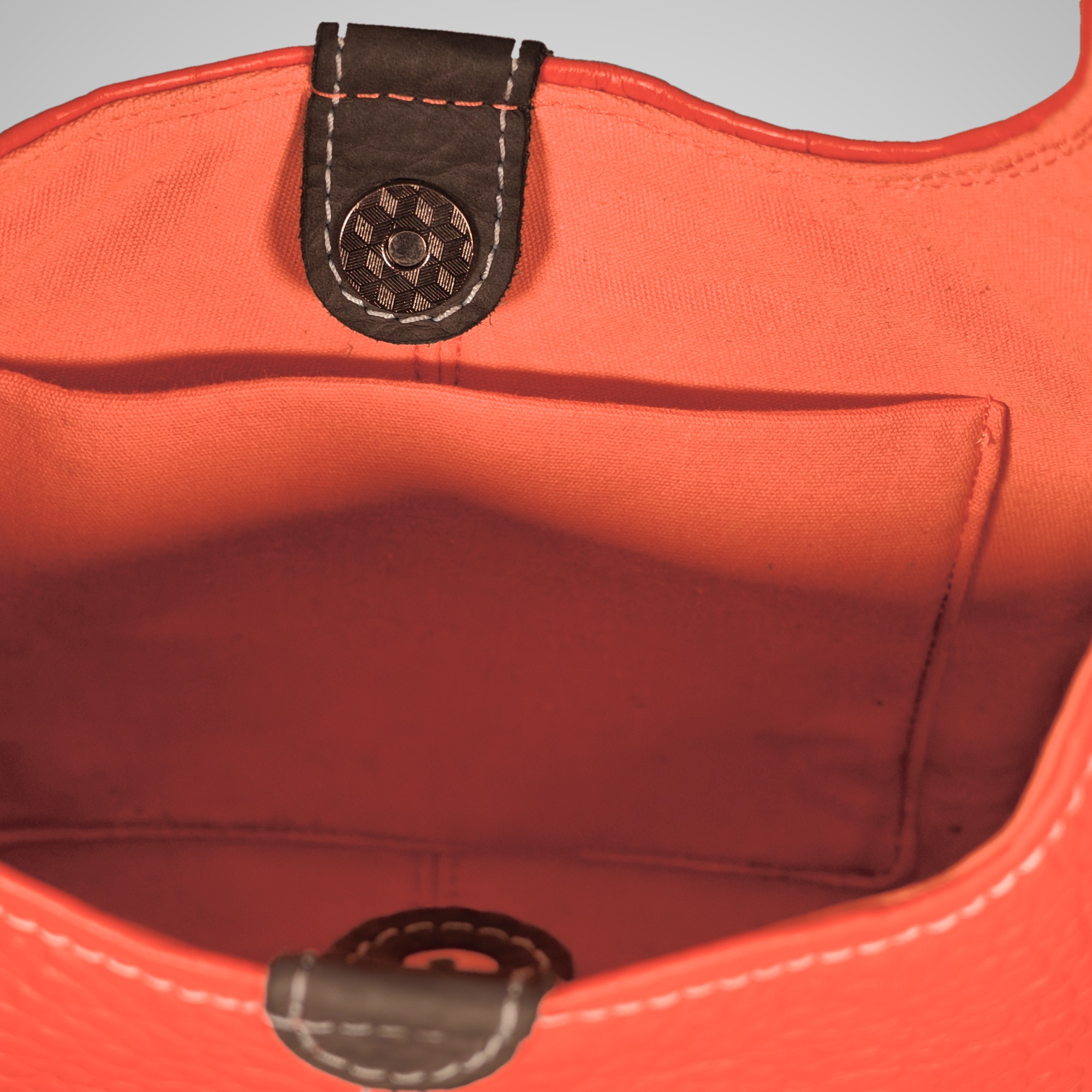 Inside the Lumengin Bubble Orange medium hobo bag: open slip pocket in the orange lining and dark grey press-stud tab
