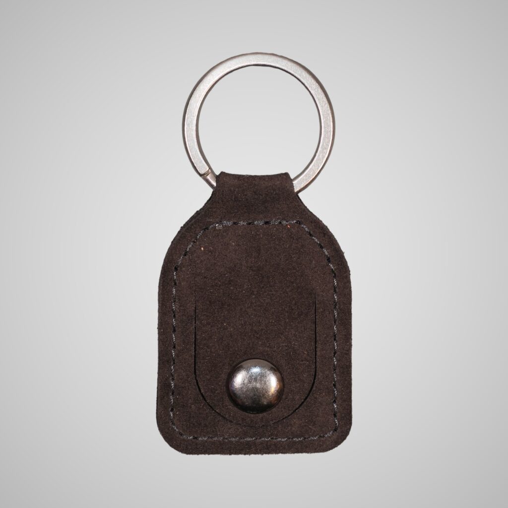 Lumengin aubergine calf suede £1 coin holder keyring, front view on soft grey background