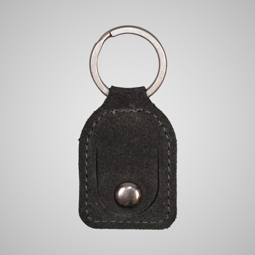 Lumengin black calf suede £1 coin holder keyring, front view on soft grey background