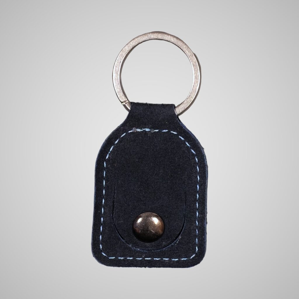 Lumengin blue calf suede £1 coin holder keyring, front view on soft grey background