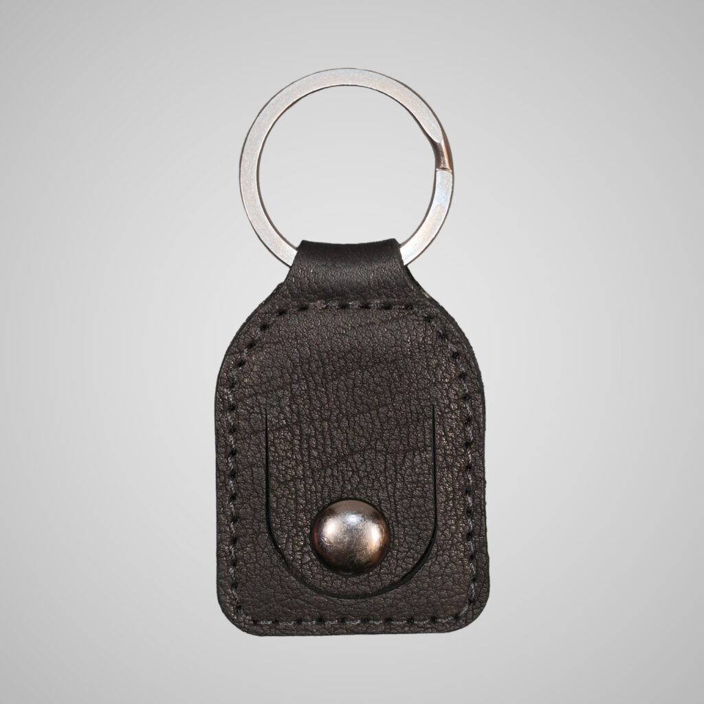 Lumengin black Janus calf £1 coin holder keyring, front view on soft grey background