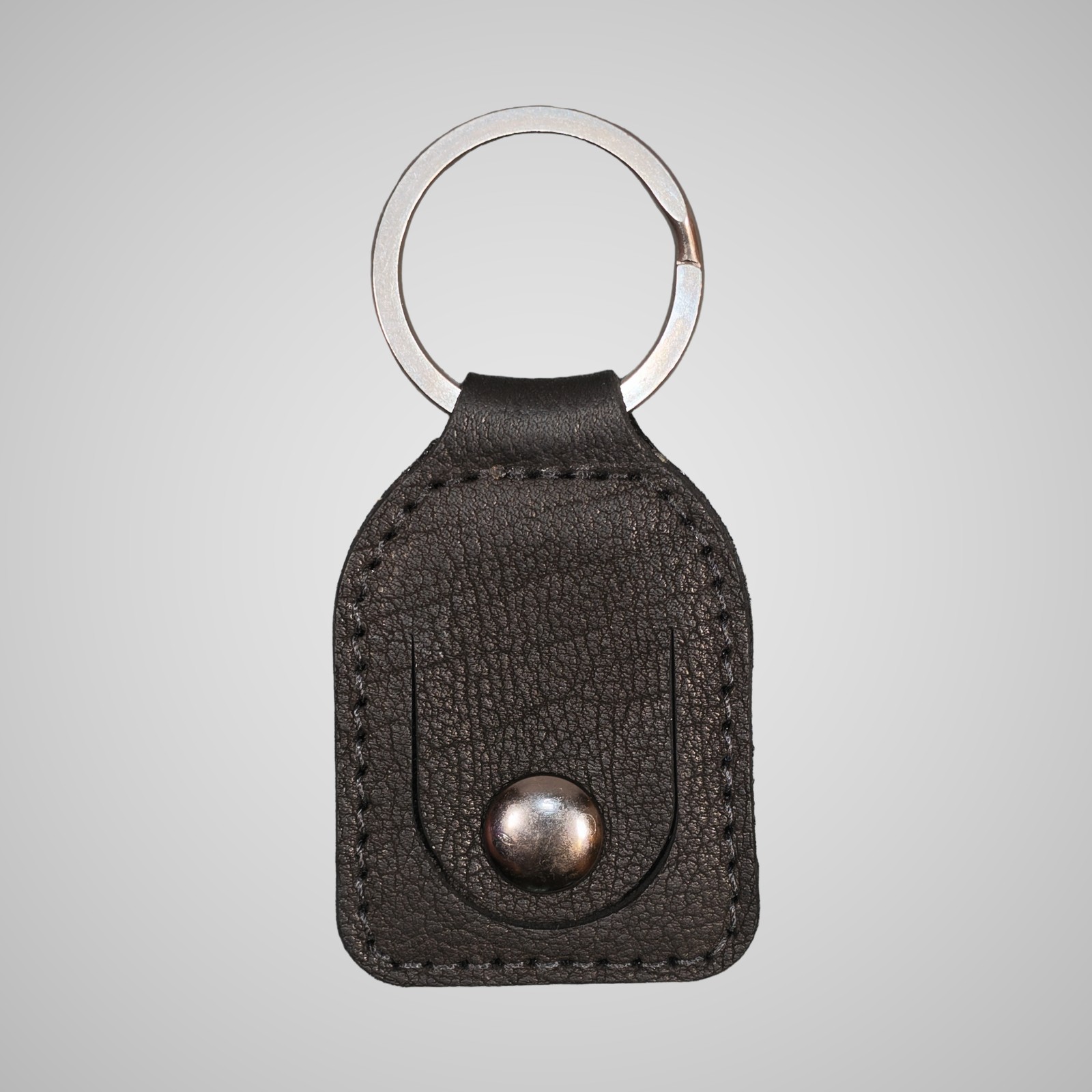 Lumengin black Janus calf £1 coin holder keyring, front view on soft grey background