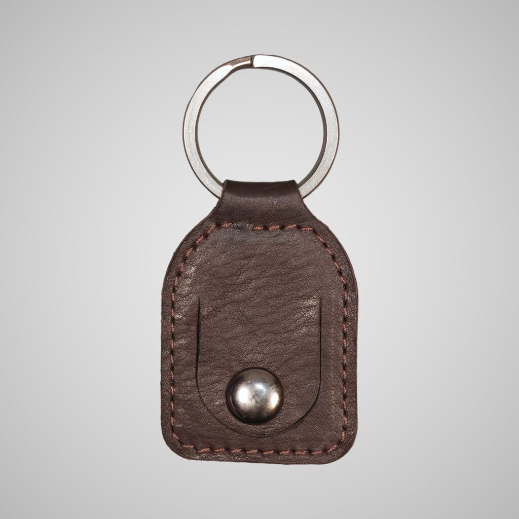 Lumengin dark brown Janus calf £1 coin holder keyring, front view on soft grey background
