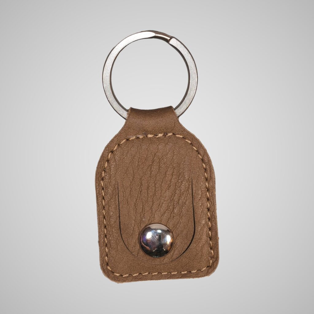 Lumengin green/gold Janus calf £1 coin holder keyring, front view on soft grey background