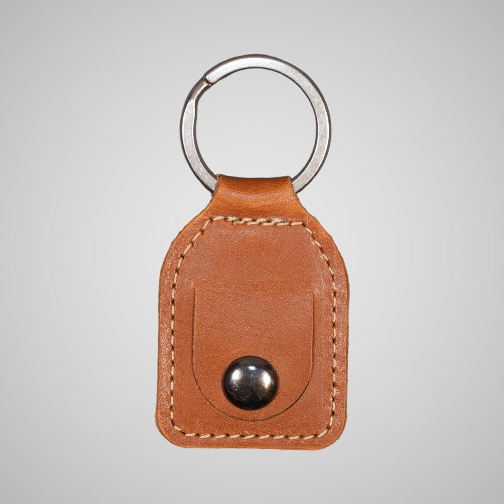 Lumengin light brown vegetable tanned leather £1 coin holder keyring, front view on soft grey background