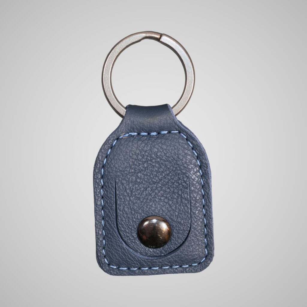 Lumengin marine blue-grey leather £1 coin holder keyring, front view on soft grey background