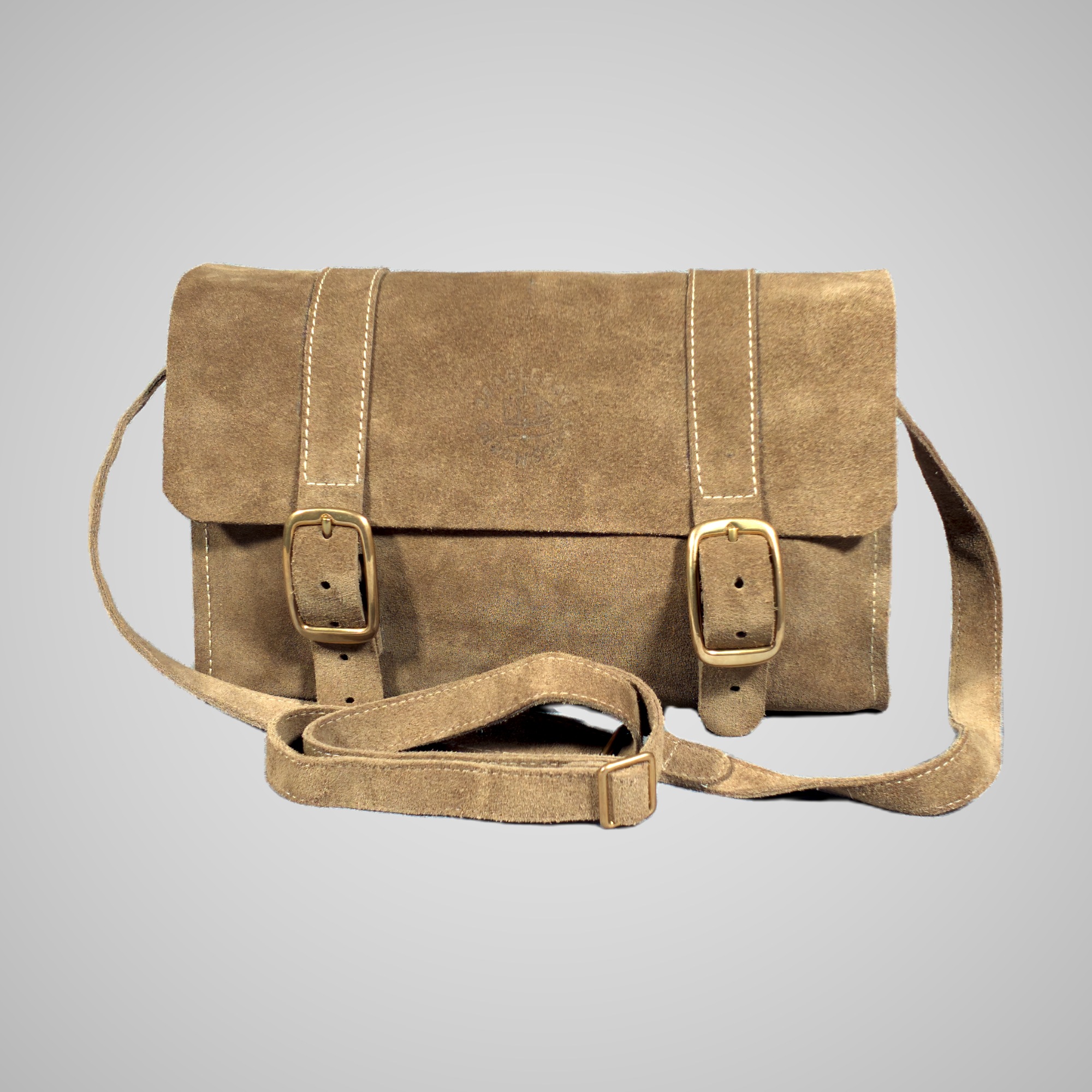 Front view of the Lumengin cross-body bag in Sand calf suede, with two brass buckles on the flap, on soft grey