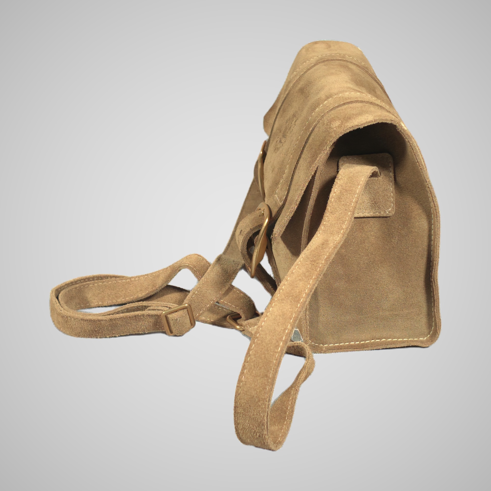 Side view of the Lumengin Sand calf suede cross-body bag, with the strap looped in front, on soft grey